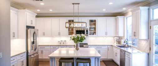 Bright modern kitchen with white cabinets and a central island.